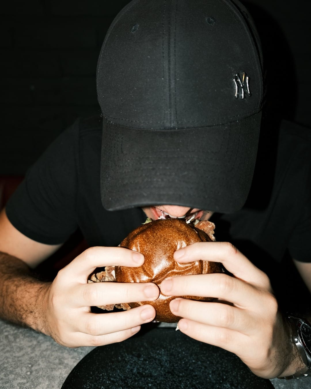 Cliente mordiendo una hamburguesa de autor de Autoria