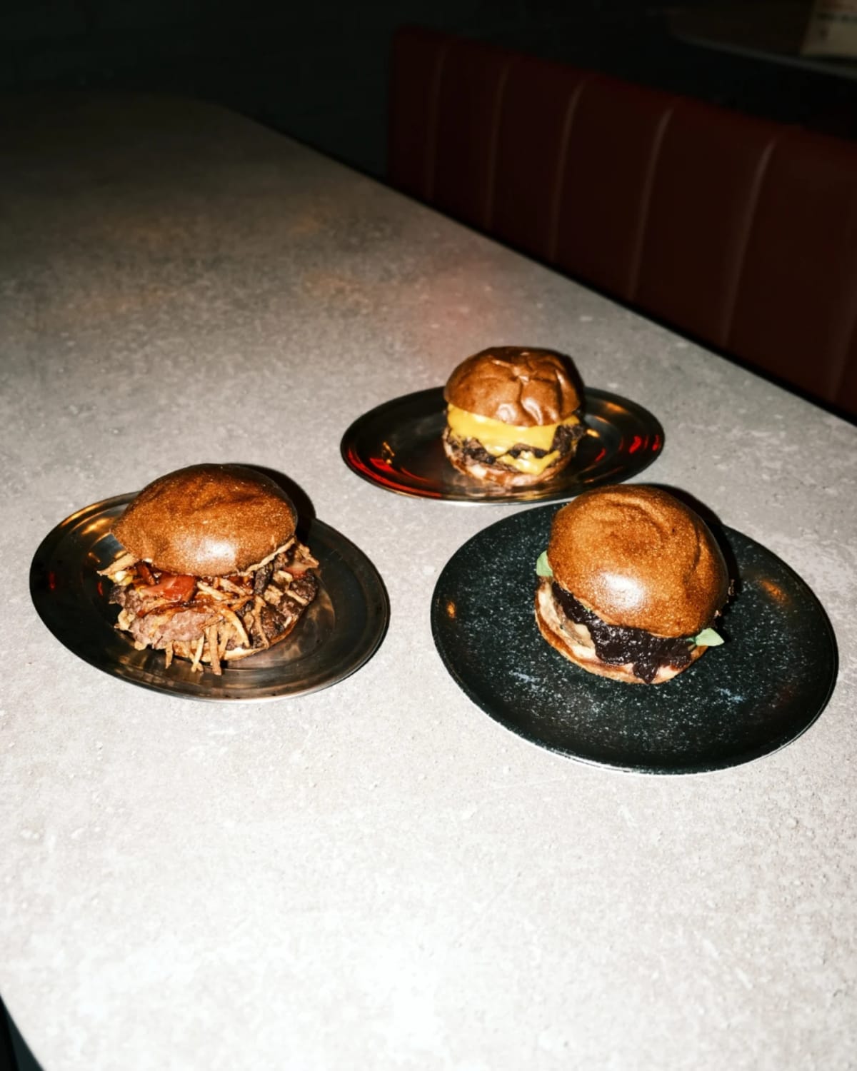 Tres hamburguesas de Autoria servidas en la barra del local